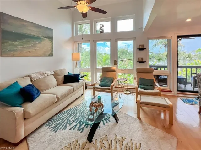 Living room with ceiling fan and hardwood / wood-style flooring