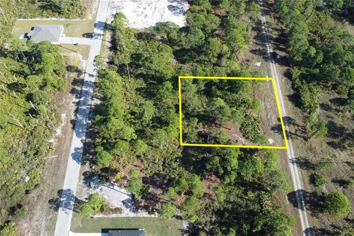 Aerial view of property and surrounding area featuring property parcel outlined