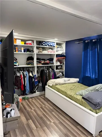 Bedroom featuring wood finished floors and a closet