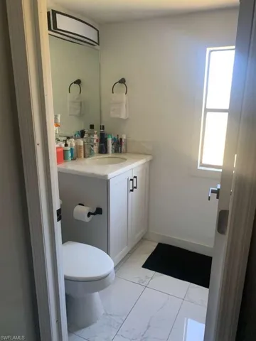 Half bath featuring vanity and light marble finish floors