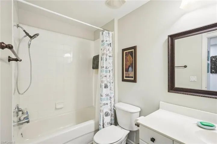 Full bathroom featuring vanity, shower / bath combination with curtain, and toilet