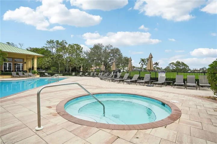 View of pool featuring a hot tub and a patio area