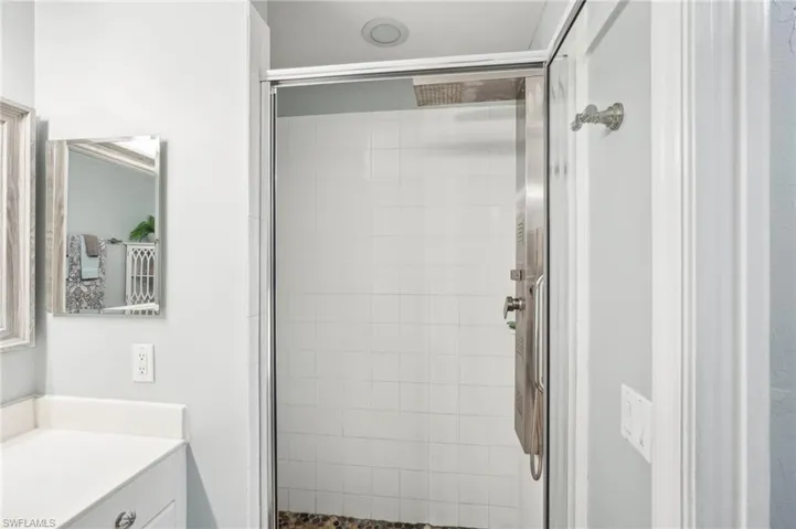 Bathroom featuring vanity and a shower with door