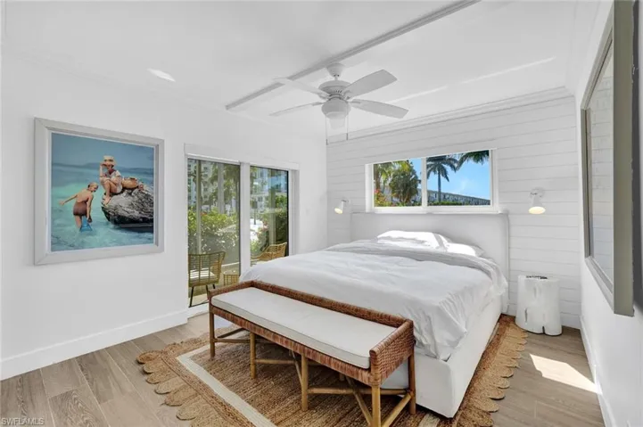 Bedroom featuring light wood-type flooring, access to exterior, crown molding, multiple windows, and ceiling fan