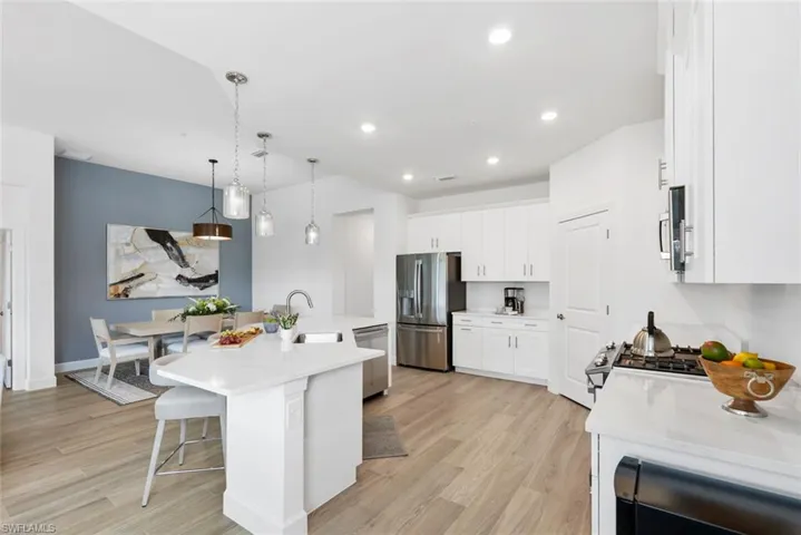 Kitchen featuring white cabinets, sink, an island with sink, and appliances with stainless steel finishes