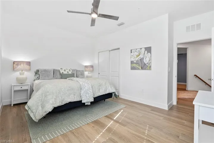 Bedroom with ceiling fan, light hardwood / wood-style floors, and a closet