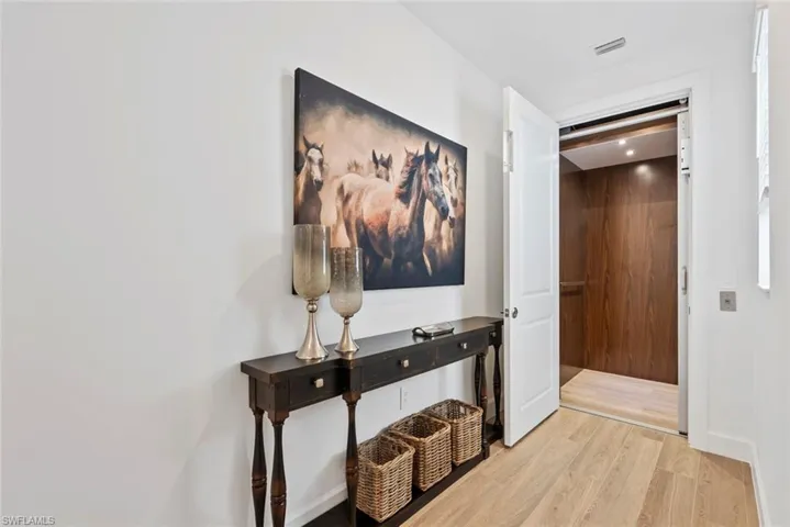 Hall with light hardwood / wood-style floors and elevator