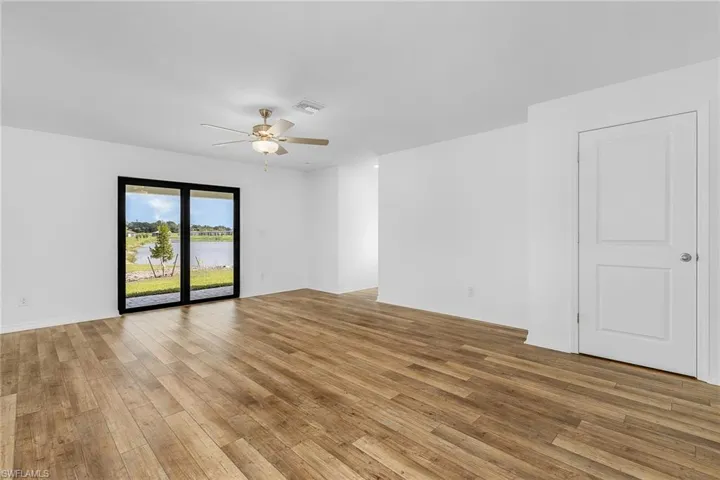 Unfurnished room with ceiling fan and light wood-type flooring