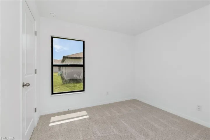 Spare room with a wealth of natural light and carpet flooring