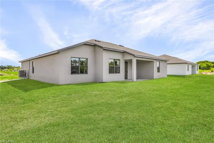 Back of property featuring a patio, cooling unit, and a yard