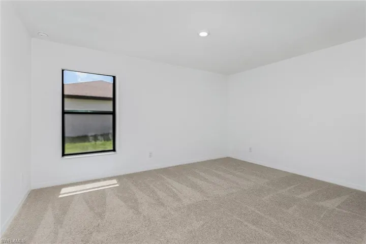 Unfurnished room featuring a wealth of natural light and carpet flooring