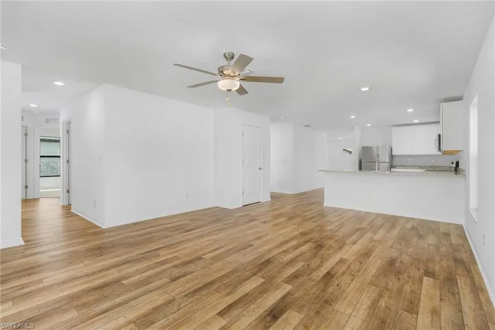 Unfurnished living room featuring light hardwood / wood-style floors and ceiling fan