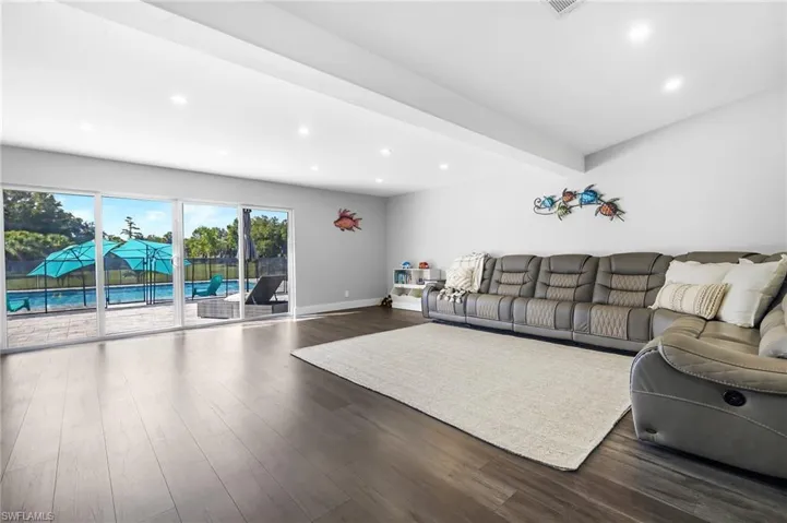 Living room featuring recessed lighting, dark wood finished floors, and baseboards