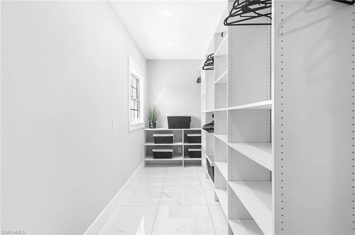 Walk in closet with marble finish floor