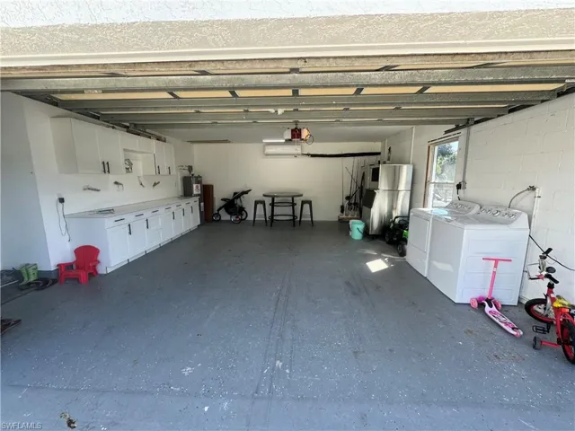 Garage with freestanding refrigerator and washer and clothes dryer