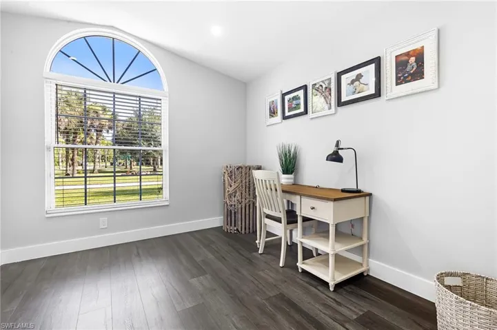 Office area with baseboards, plenty of natural light, and dark wood-style floors