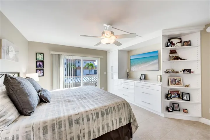 Bedroom with access to exterior, light tile patterned floors, and ceiling fan