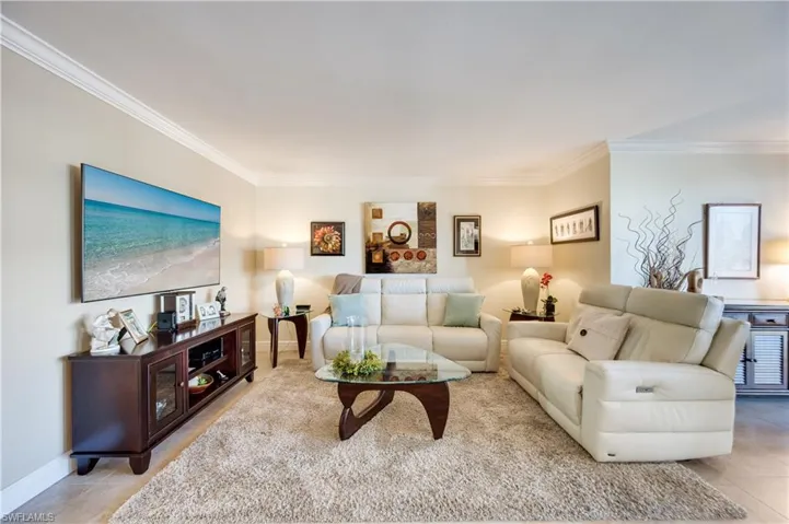 Living area featuring crown molding and light tile patterned floors