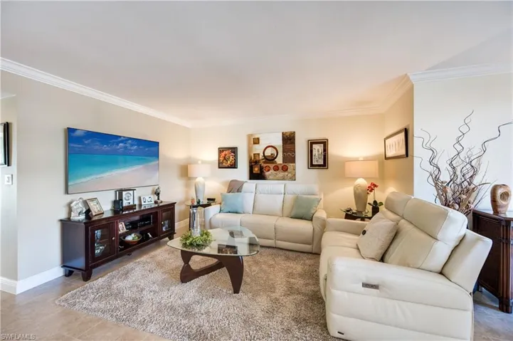 Living area featuring crown molding and light tile patterned flooring