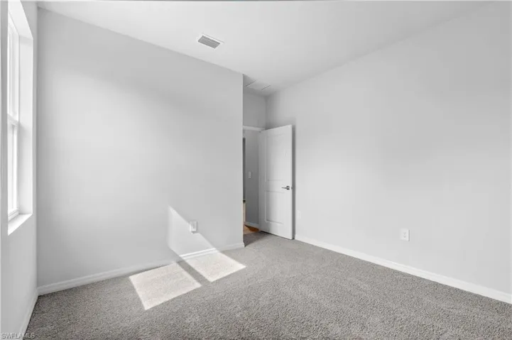 Carpeted empty room featuring baseboards