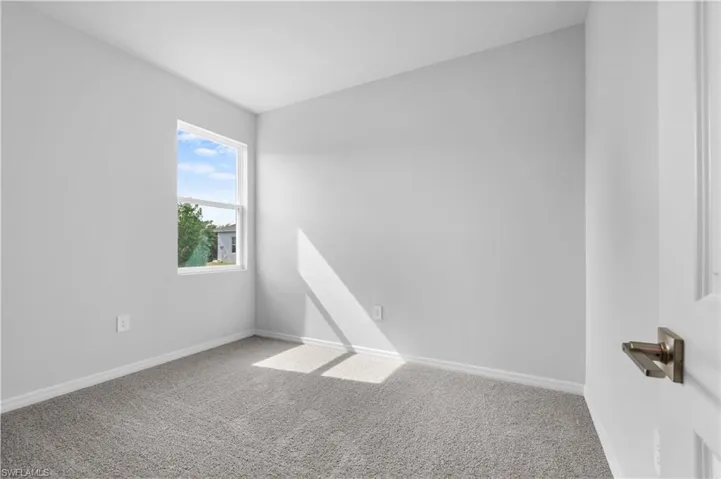 Empty room with carpet floors and baseboards
