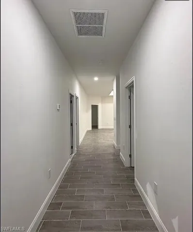 Hall featuring baseboards and wood finish floors