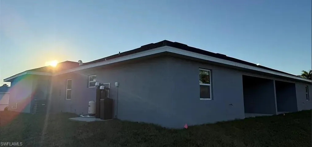 Rear view of property featuring stucco siding and a yard