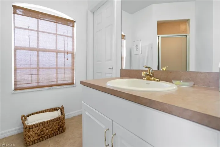 Full bath featuring vanity, a stall shower, and light tile patterned floors