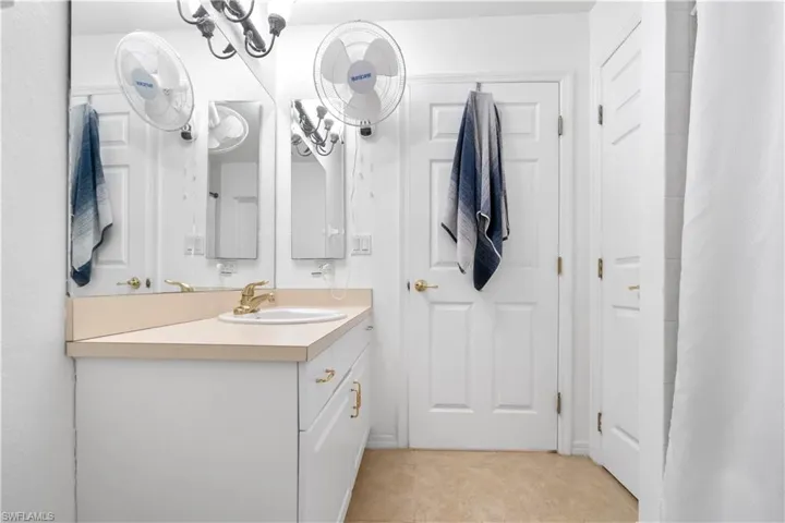 Bathroom featuring vanity, curtained shower, and light tile patterned flooring