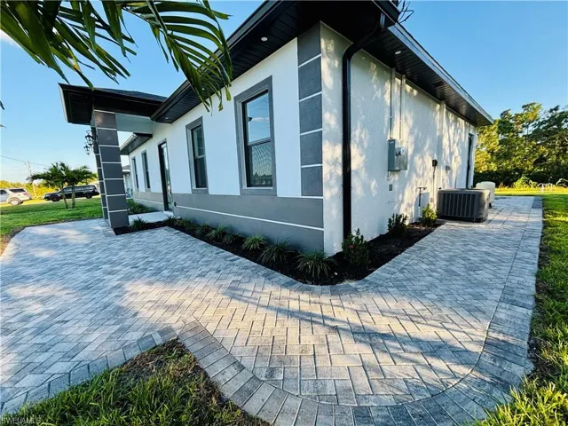 View of home's exterior with stucco siding and a cooling unit