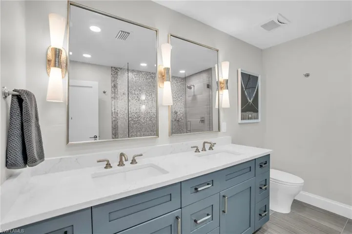 Primary Bathroom with dual sinks and designer touches like the mirrors and light fixtures