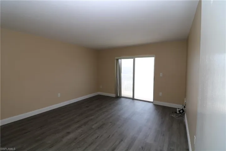 Spare room with baseboards and dark wood finished floors