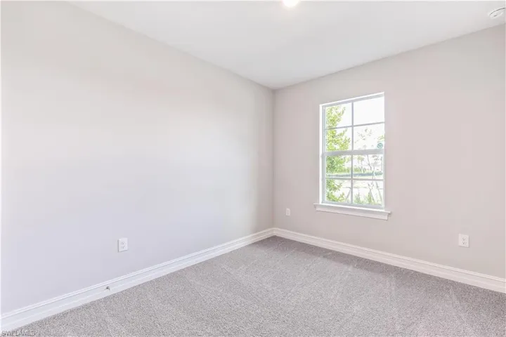 Unfurnished room with baseboards and carpet