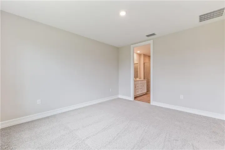 Unfurnished room with light colored carpet and recessed lighting