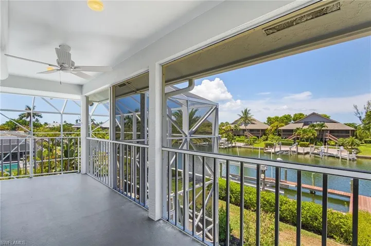 Balcony featuring a ceiling fan, a water view, and a sunroom