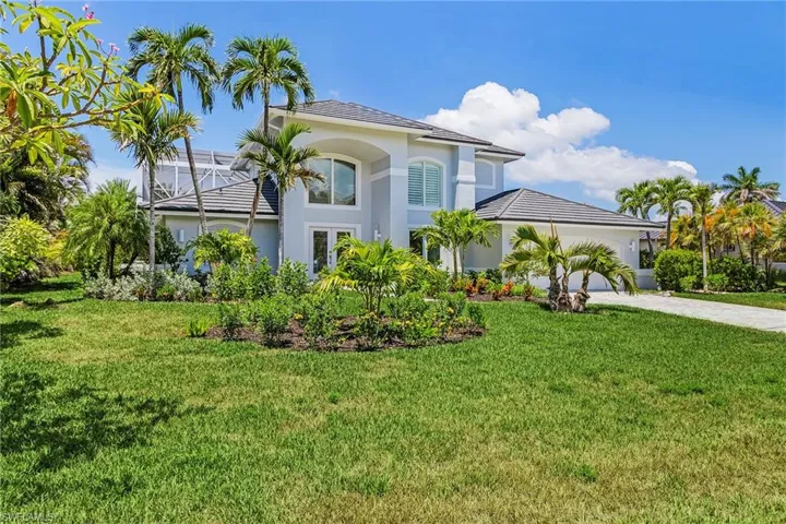 View of front of property featuring a front yard, stucco siding, driveway, and an attached garage