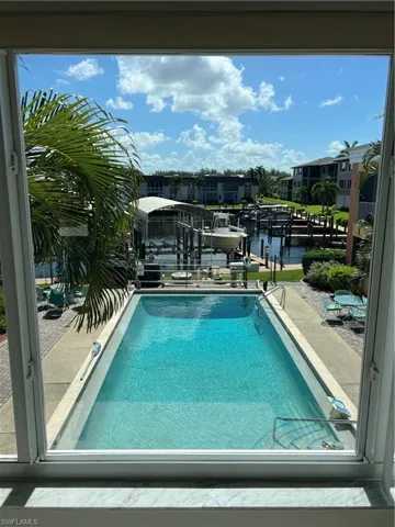 View of swimming pool with a boat dock and a water view