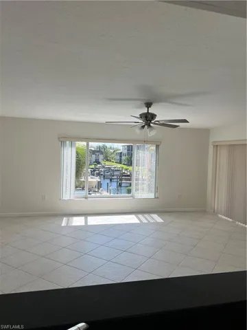 Tiled spare room featuring ceiling fan