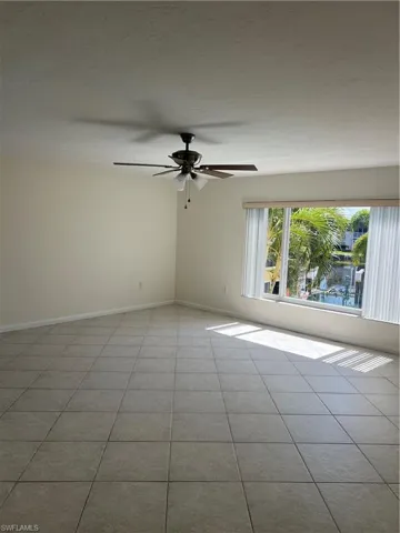 Empty room featuring ceiling fan and light tile patterned flooring