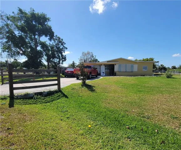 View of yard with fence and concrete driveway