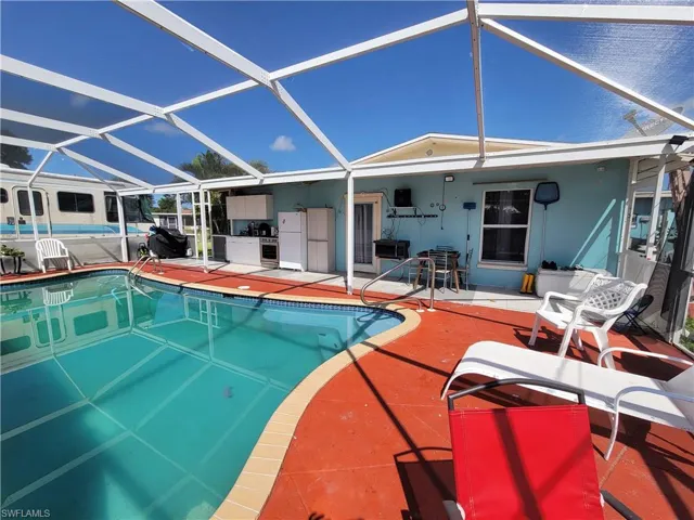 Pool featuring glass enclosure and a patio