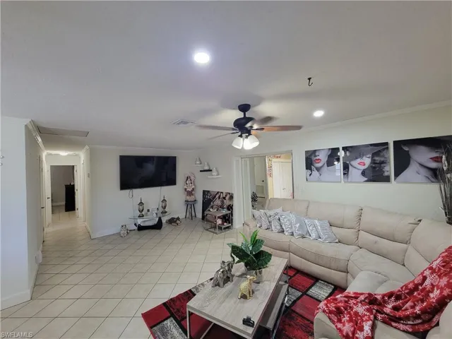 Living room with recessed lighting, light tile patterned floors, crown molding, visible vents, and ceiling fan