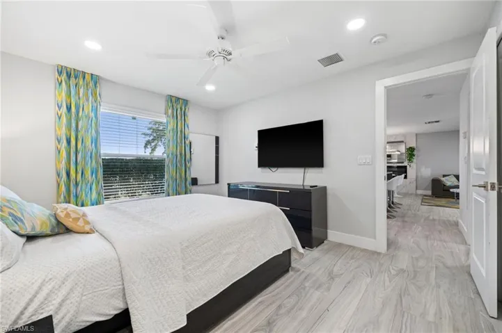 Bedroom featuring light wood-type flooring, ceiling fan, and recessed lighting