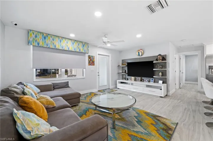 Living area with ceiling fan, recessed lighting, and light wood-style floors