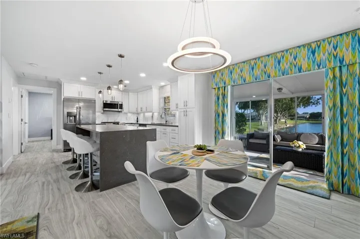 Dining space with light wood-style flooring, a water view, and recessed lighting