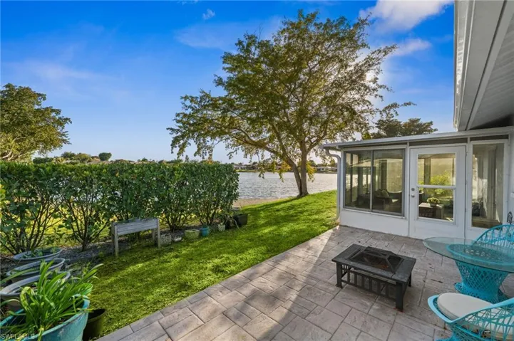 View of patio / terrace featuring a sunroom, a water view, and a fire pit