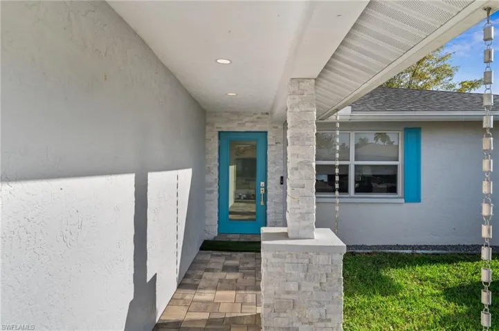 Property entrance with stucco siding and a porch
