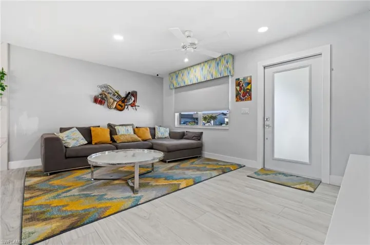 Living room with ceiling fan, recessed lighting, and light wood finished floors
