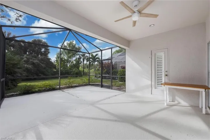 View of patio with a sunroom, a ceiling fan, and glass enclosure