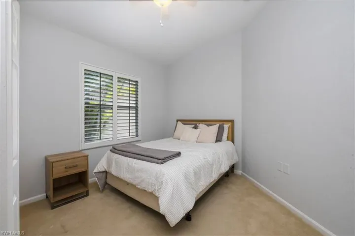 Bedroom with carpet, a ceiling fan, and lofted ceiling